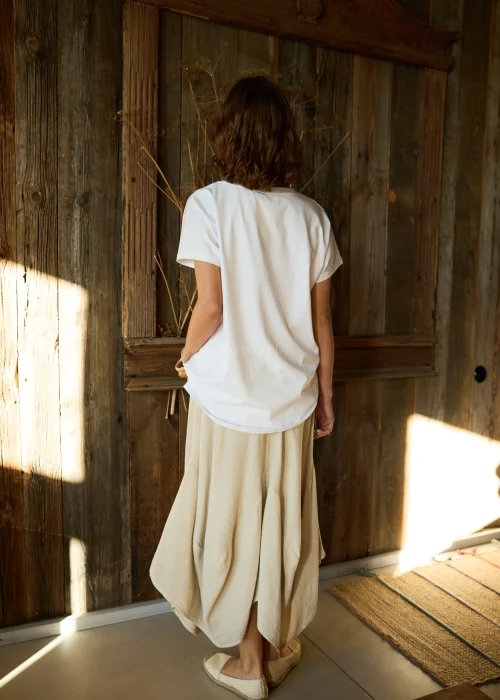 Beżowe spodnie damskie z dodatkiem lnu o szerokim, asymetrycznym kroju, z elastyczną talią i kieszeniami z klapką, w stylu casualowym.