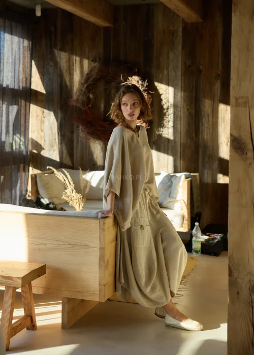 Beżowe spodnie damskie z dodatkiem lnu o szerokim, asymetrycznym kroju, z elastyczną talią i kieszeniami z klapką, w stylu casualowym.