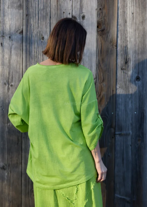 Bluzka damska w intensywnym zielonym kolorze z luźnym krojem i ozdobnym wiązaniem z przodu.