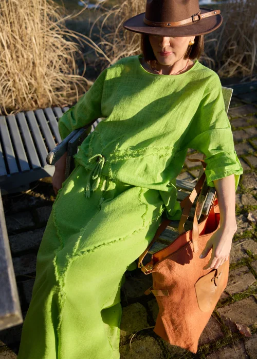 Bluzka damska w intensywnym zielonym kolorze z luźnym krojem i ozdobnym wiązaniem z przodu.