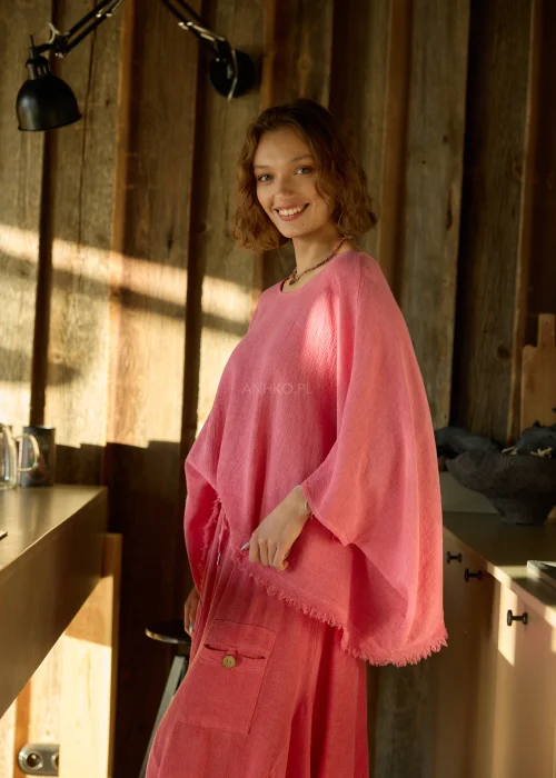 Malinowa bluzka damska oversize z dodatkiem lnu, o luźnym kroju i szerokich rękawach, stylizowana z lekkimi spodniami w naturalnym wnętrzu.