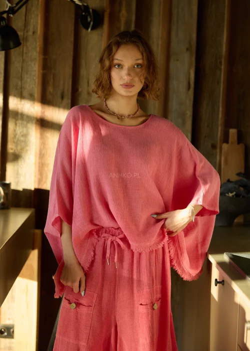 Malinowa bluzka damska oversize z dodatkiem lnu, o luźnym kroju i szerokich rękawach, stylizowana z lekkimi spodniami w naturalnym wnętrzu.