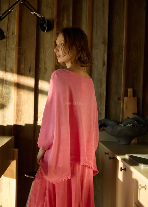 Malinowa bluzka damska oversize z dodatkiem lnu, o luźnym kroju i szerokich rękawach, stylizowana z lekkimi spodniami w naturalnym wnętrzu.