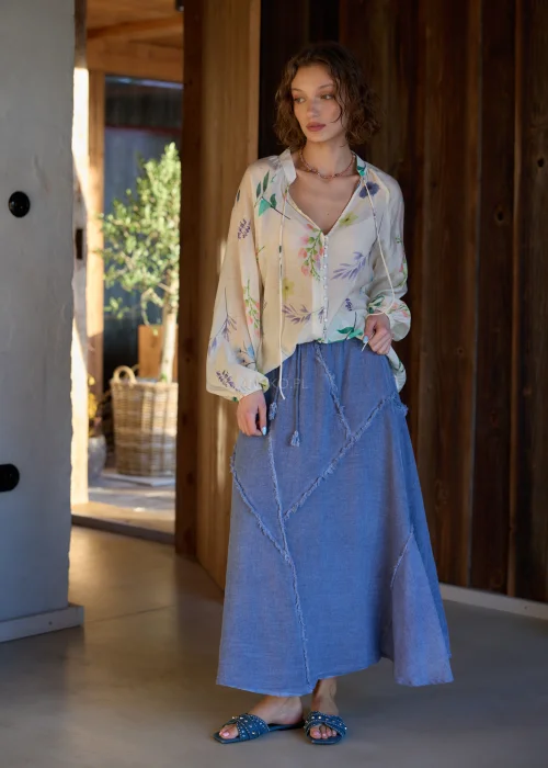 Spódnica midi w kolorze niebieskim, o rozkloszowanym fasonie, z elastyczną talią i dekoracyjnymi, surowymi przeszyciami tworzącymi geometryczny wzór.