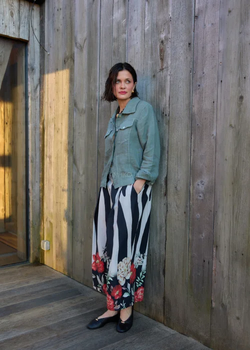 Spodnie damskie w czarno-białe pasy z kwiatowym nadrukiem, szerokie nogawki i wysoki stan, elegancki, lekko oversize fason.