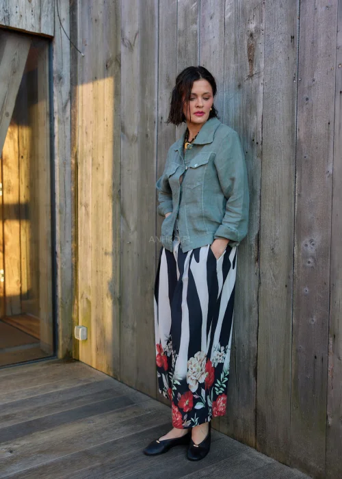 Spodnie damskie w czarno-białe pasy z kwiatowym nadrukiem, szerokie nogawki i wysoki stan, elegancki, lekko oversize fason.