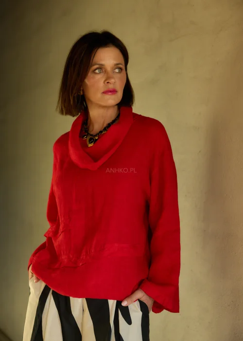 Lniana bluzka damska w intensywnym czerwonym kolorze z długim rękawem i luźnym krojem, dekolt typu komin, stylizacja ze spódnicą w kwiatowy wzór.