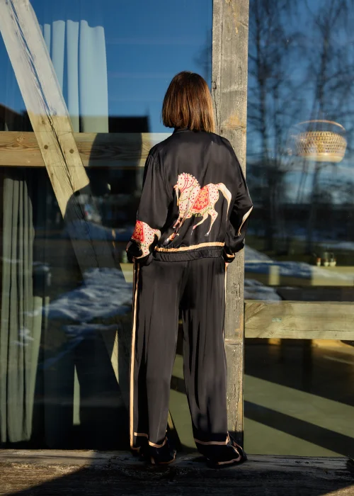 Czarna bluza damska z nadrukiem koni, zapinana na zamek, z długim rękawem i elastycznym wykończeniem, w stylu casualowym.