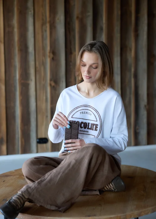 Biała bluzka damska Premium Chocolate z haftowanym napisem na przodzie, dekoltem w serek i luźnym fasonem do codziennych stylizacji.