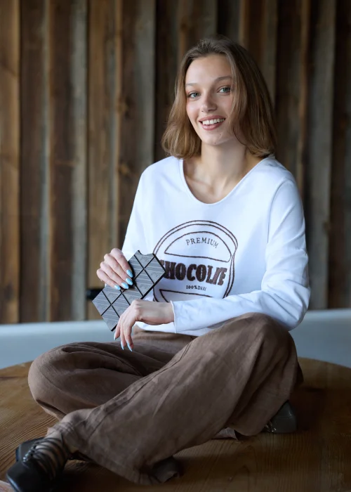Biała bluzka damska Premium Chocolate z haftowanym napisem na przodzie, dekoltem w serek i luźnym fasonem do codziennych stylizacji.