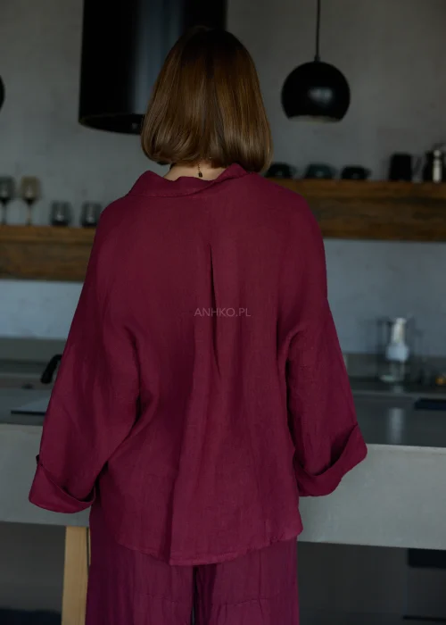 Bordowa lniana koszula oversize z długim rękawem i guzikami, o luźnym fasonie, zestawiona z bordowymi spodniami, stylizacja w naturalnym, minimalistycznym klimacie.