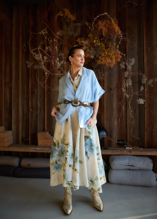 Lniana marynarka damska w kolorze baby blue o luźnym kroju, z krótkim rękawem i klasycznym kołnierzem, stylizacja warstwowa w naturalnym, eleganckim klimacie.