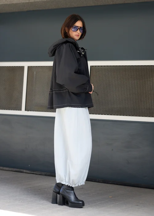 Czarna kurtka oversize z kapturem i kontrastowymi przeszyciami. Lekki model o sportowo-miejskim charakterze z regulacją w talii, idealny do nowoczesnych stylizacji casualowych i streetwearowych.