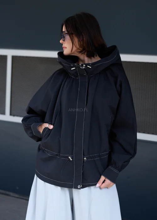 Czarna kurtka oversize z kapturem i kontrastowymi przeszyciami. Lekki model o sportowo-miejskim charakterze z regulacją w talii, idealny do nowoczesnych stylizacji casualowych i streetwearowych.