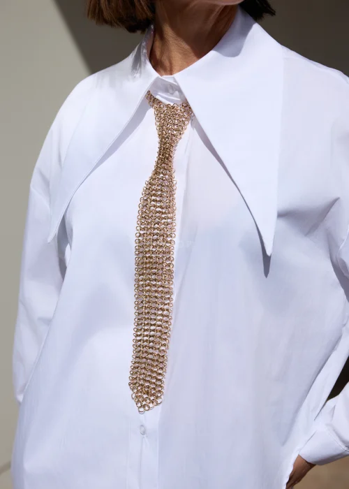 Dekoracyjny naszyjnik w formie złotej siateczki inspirowanej krawatem. Elegancki i nowoczesny akcent, który efektownie uzupełnia koszulowe stylizacje.