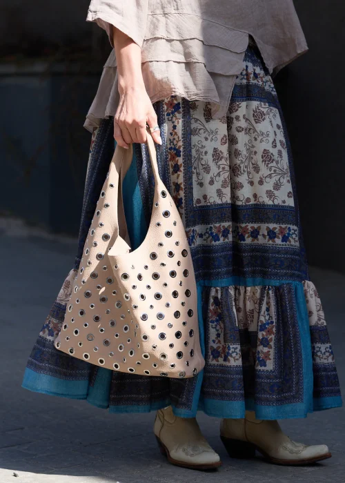 Beżowa torba damska z kosmetyczką  w stylu boho. Miękki model shopper z efektownymi oczkami i szerokim paskiem, idealny do codziennych stylizacji