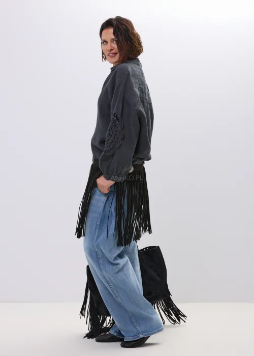 Czarny pasek damski z długimi frędzlami i ozdobnymi metalowymi klamrami w stylu boho western. Efektowny model pięknie podkreśla talię, dodając stylizacji lekkości i charakteru.
