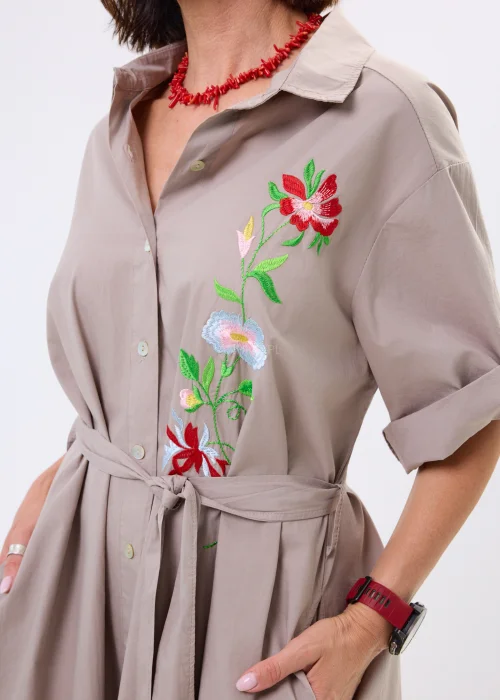 Sukienka koszulowa midi w kolorze taupe z kolorowym haftem kwiatowym i wiązaniem w talii. Model z kołnierzykiem i podwijanymi rękawami wyróżnia się eleganckim, kobiecym fasonem.