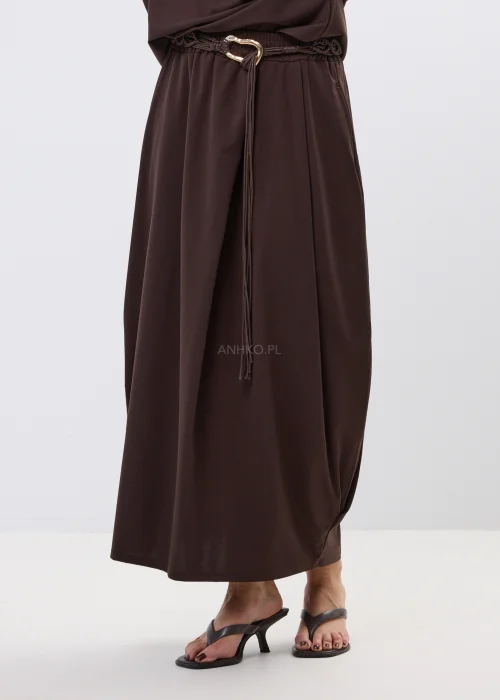 Brązowa spódnica maxi z elastyczną talią i ozdobnym paskiem. Lekko drapowany fason pięknie układa się w ruchu i dodaje stylizacji nowoczesnej elegancji.
