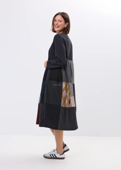 Czarna sukienka midi patchwork z kolorowymi panelami i luźnym fasonem. Oryginalny model łączący paski, geometryczne wzory i nowoczesny styl.