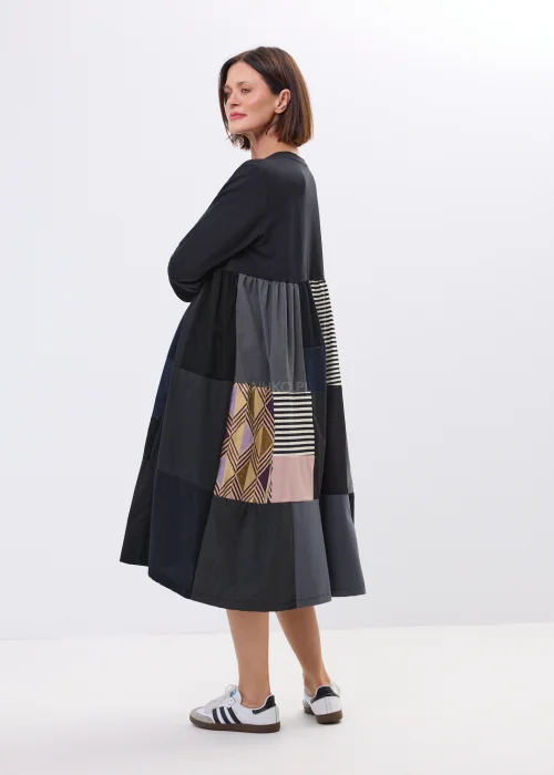 Czarna sukienka midi patchwork z kolorowymi panelami i luźnym fasonem. Oryginalny model łączący paski, geometryczne wzory i nowoczesny styl.