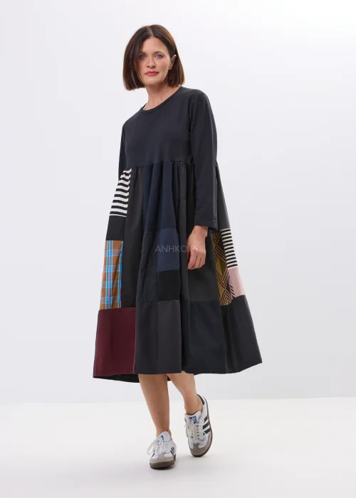 Czarna sukienka midi patchwork z kolorowymi panelami i luźnym fasonem. Oryginalny model łączący paski, geometryczne wzory i nowoczesny styl.