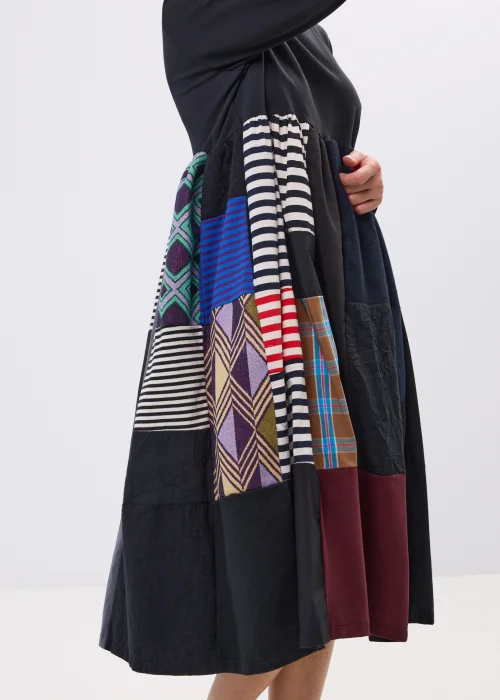 Czarna sukienka midi patchwork z kolorowymi panelami i luźnym fasonem. Oryginalny model łączący paski, geometryczne wzory i nowoczesny styl.