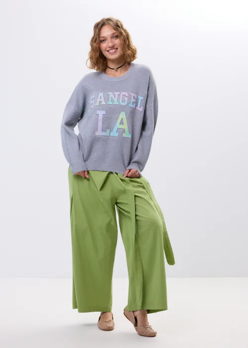 Szary sweter oversize z kolorowym napisem „Los Angeles” w pastelowych odcieniach. Miękki dzianinowy materiał, luźny fason i obniżona linia ramion nadają całości casualowego charakteru, idealnego do codziennych i streetwearowych stylizacji.