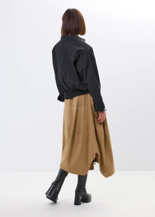 Spódnica midi w karmelowym odcieniu o asymetrycznym, lekko oversize’owym fasonie. Model z efektownymi przeszyciami i dużą kieszenią po boku nadaje stylizacji nowoczesnego charakteru i swobodnego ruchu.