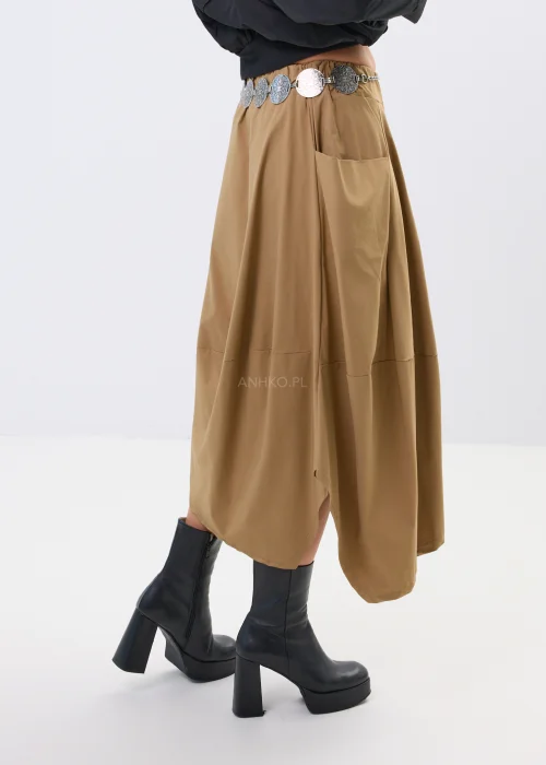 Spódnica midi w karmelowym odcieniu o asymetrycznym, lekko oversize’owym fasonie. Model z efektownymi przeszyciami i dużą kieszenią po boku nadaje stylizacji nowoczesnego charakteru i swobodnego ruchu.