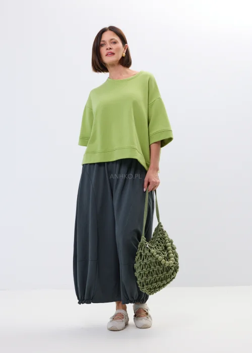 Zielona pleciona torebka damska typu siatka z dekoracyjnymi koralikami i długim uchwytem na ramię. Lekki model w stylu boho i casual.