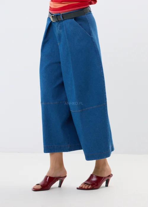 Granatowe jeansy damskie culotte z szerokimi nogawkami i wysokim stanem. Luźny fason w miejskiej stylizacji z bordowymi klapkami.