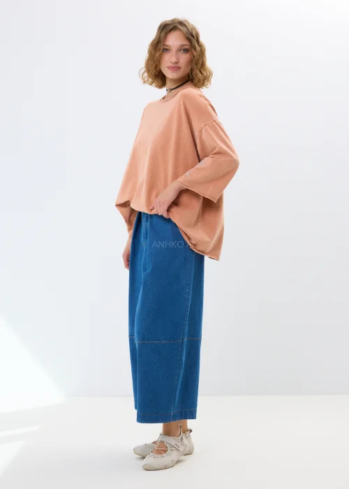 Oversize’owa bluzka w morelowym odcieniu z szerokimi rękawami i haftowanym kwiatem. Swobodny fason zapewnia wygodę i casualowy styl.