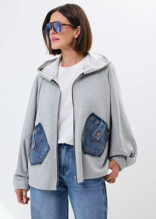 Szara bluza oversize z kapturem i jeansowymi kieszeniami. Luźny fason oraz surowe denimowe detale nadają całości casualowego, miejskiego charakteru.