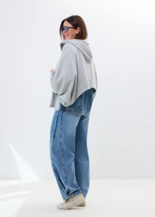 Szara bluza oversize z kapturem i jeansowymi kieszeniami. Luźny fason oraz surowe denimowe detale nadają całości casualowego, miejskiego charakteru.