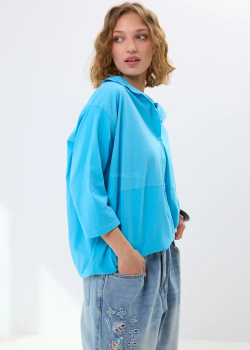 Koszula damska baby blue o luźnym fasonie z kołnierzykiem i rękawem 3/4. Lekki materiał i swobodny krój sprawiają, że świetnie wygląda w codziennych stylizacjach.