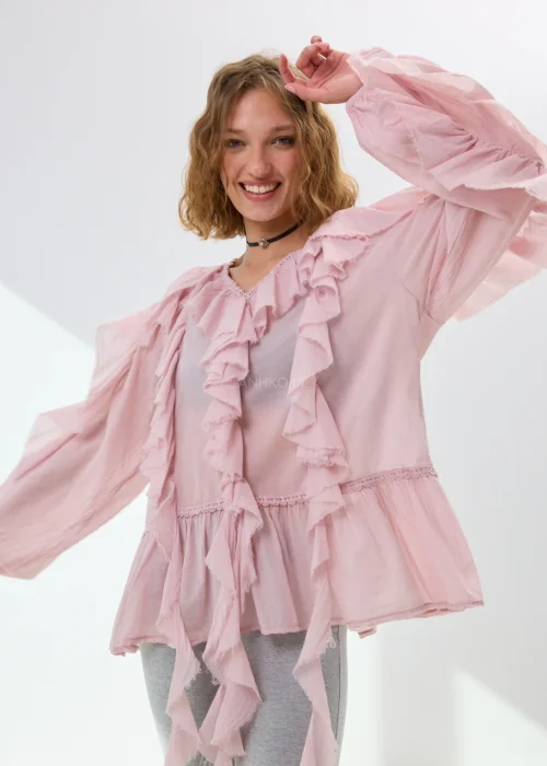 Pudroworóżowa bluzka damska z falbanami i luźnym fasonem boho. Zwiewny model z szerokimi rękawami i romantycznym wykończeniem przyciąga uwagę efektownymi detalami.