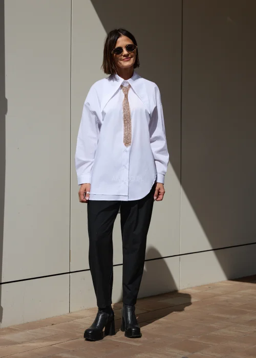 Damska biała koszula oversize z szerokim kołnierzem i wydłużonym fasonem. Minimalistyczny krój nadaje stylizacji nowoczesny, elegancki charakter.