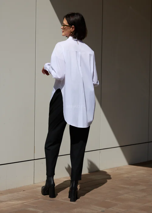 Damska biała koszula oversize z szerokim kołnierzem i wydłużonym fasonem. Minimalistyczny krój nadaje stylizacji nowoczesny, elegancki charakter.
