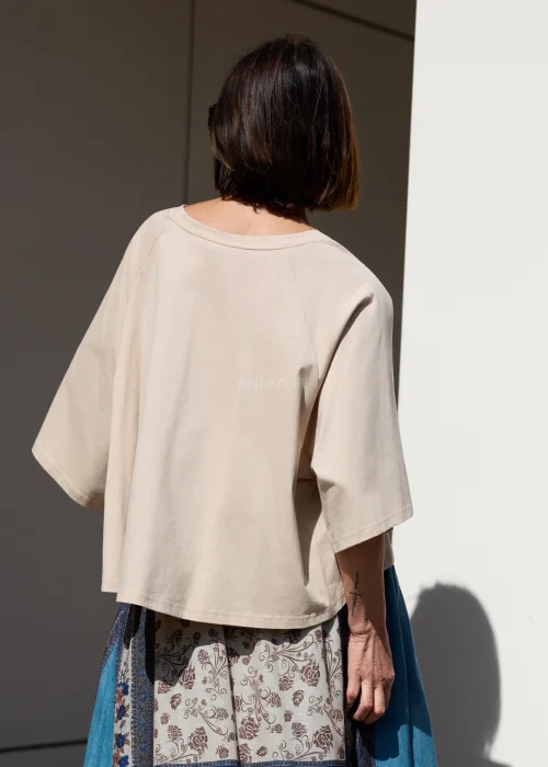 Damska beżowa bluzka oversize z szerokim rękawem i minimalistycznym fasonem w stylizacji boho.