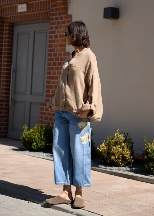 Jeansowe spodnie wide leg z naszywkami moro i luźnym fasonem w miejskiej casualowej stylizacji.