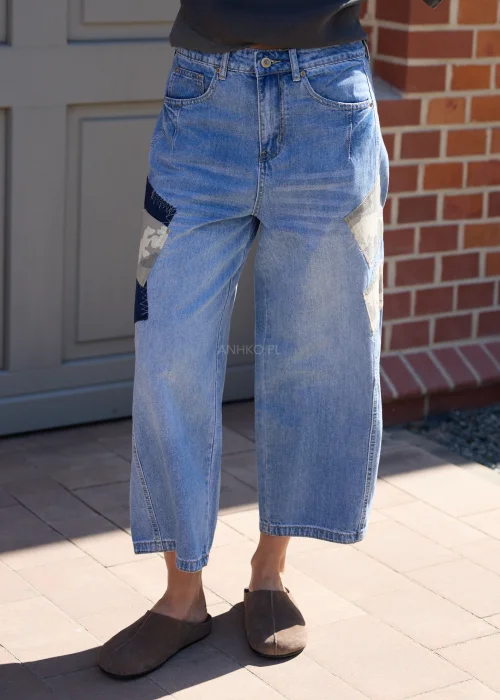 Jeansowe spodnie wide leg z naszywkami moro i luźnym fasonem w miejskiej casualowej stylizacji.