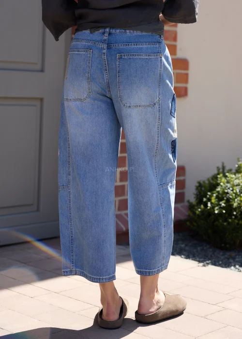 Jeansowe spodnie wide leg z naszywkami moro i luźnym fasonem w miejskiej casualowej stylizacji.