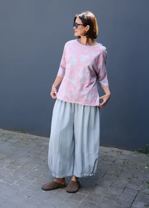Szare spodnie dresowe oversize z szerokimi nogawkami i gumką przy kostkach w casualowej stylizacji.