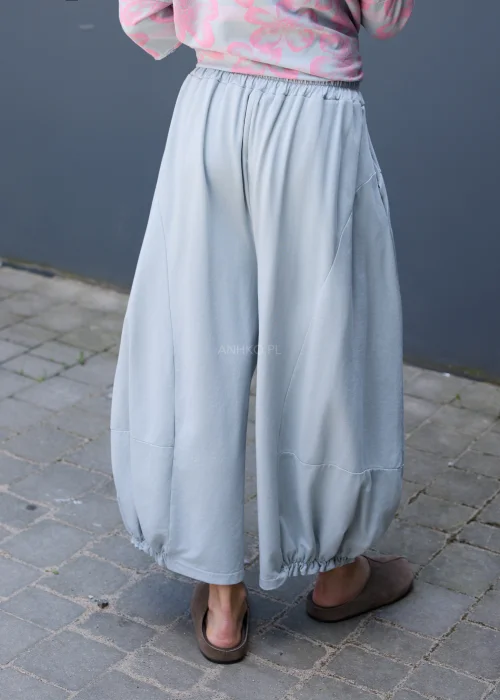 Szare spodnie dresowe oversize z szerokimi nogawkami i gumką przy kostkach w casualowej stylizacji.