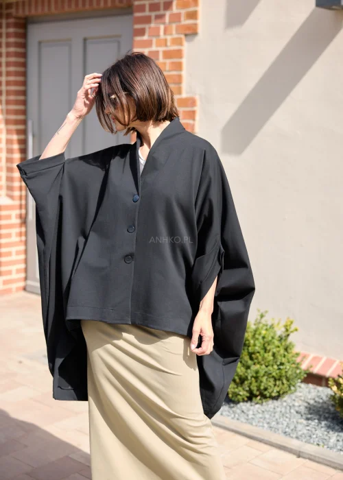 Lekki damski płaszcz oversize w kolorze czarnym o kroju kimono z szerokimi rękawami i minimalistycznym zapięciem na guziki.