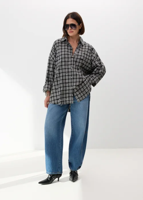 Oversize’owa koszula damska w czarno-białą kratę z efektem delikatnych przetarć i surowym wykończeniem. Luźny fason w stylu grunge świetnie komponuje się z jeansami wide leg i miejskimi stylizacjami casual.