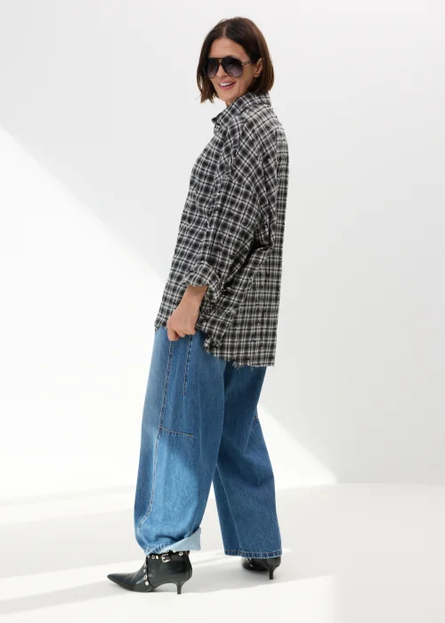 Oversize’owa koszula damska w czarno-białą kratę z efektem delikatnych przetarć i surowym wykończeniem. Luźny fason w stylu grunge świetnie komponuje się z jeansami wide leg i miejskimi stylizacjami casual.
