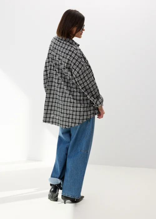 Oversize’owa koszula damska w czarno-białą kratę z efektem delikatnych przetarć i surowym wykończeniem. Luźny fason w stylu grunge świetnie komponuje się z jeansami wide leg i miejskimi stylizacjami casual.