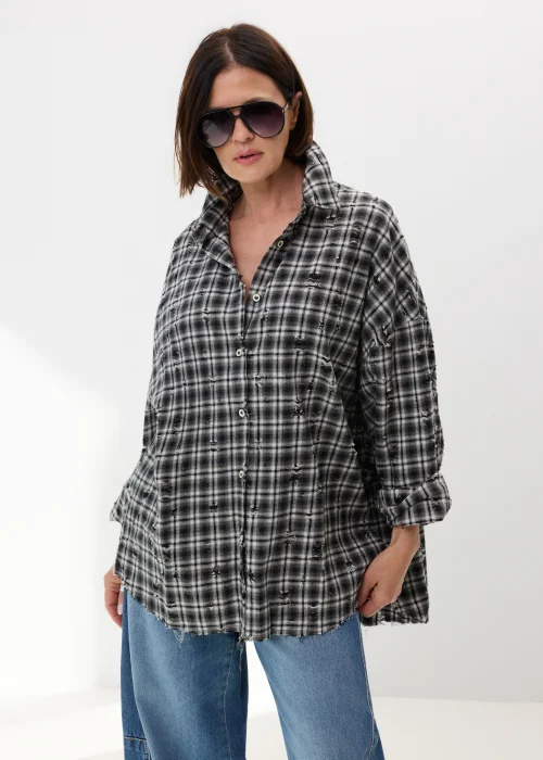 Oversize’owa koszula damska w czarno-białą kratę z efektem delikatnych przetarć i surowym wykończeniem. Luźny fason w stylu grunge świetnie komponuje się z jeansami wide leg i miejskimi stylizacjami casual.